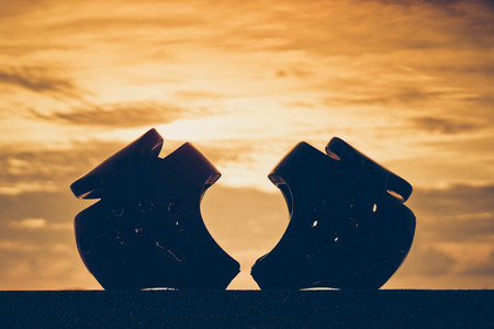 Red and blue Taekwondo head guards with on sunset silhouette backgroundの写真素材