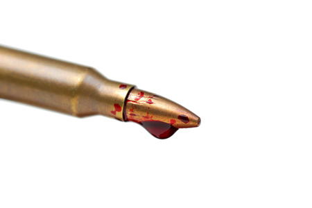 A rifle bullet with red blood / Bloodshed business / selling weapons causing deathの写真素材