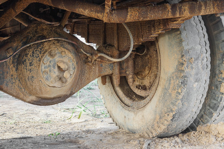 Old wheels of a big truck covered with mud and dirtの写真素材