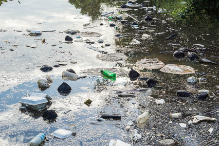 Water pollution - Plastic and foam garbage floating on the surface of the river - Environmental...