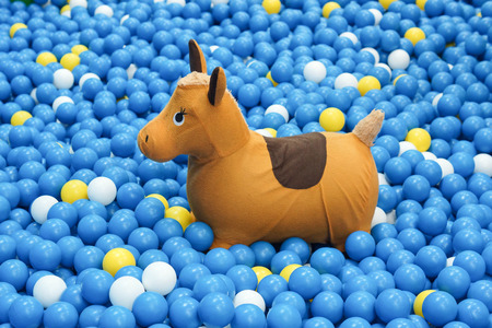 Rocking horse for kid in a big ball pit