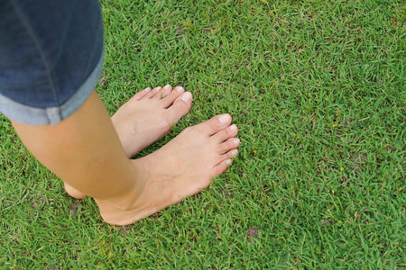 Female feet standing on green grass / Relaxing conceptの写真素材