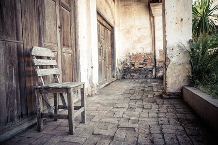 Old wooden chairs in front of old buildingの写真素材