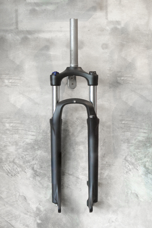 Front suspension for mountain bike hung on concrete wall backgroundの写真素材