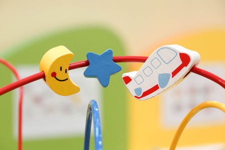 Wooden toy on rail in the shape of star, moon, and a plane for kids playing and practicing hand movementの写真素材