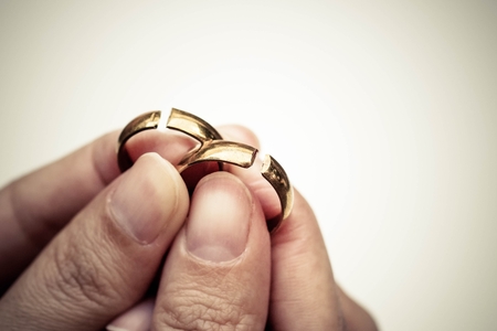 Hand holding broken rings / Divorce cond ending relationship conceptの写真素材