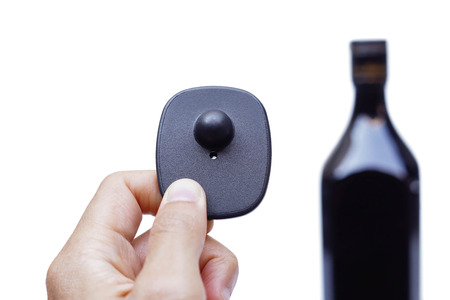 RFID hard tag isolated - Shoplifting and anti-theft system - Electronic Article Surveillance system used with high-value goods - Alcoholic drinksの写真素材