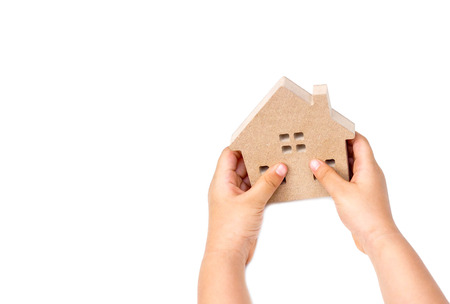 Hand of a kid holding a wooden houseの写真素材