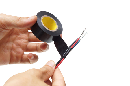 Hand of the electrician using vinyl electrical tape with electricity wireの写真素材
