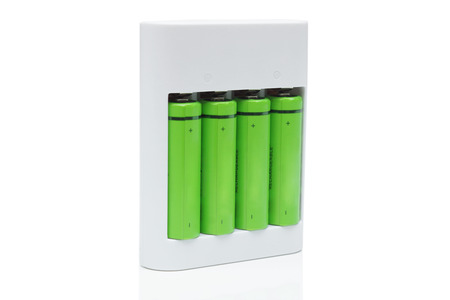 Green rechargeable aa battery in a charger - using  environmentally friendly product conceptの写真素材