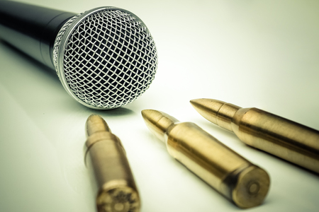 Microphone vs. Bullets / Freedom of the press is at risk concept / World press freedom day concept