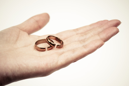 Hand holding broken rings / Divorce and ending relationship conceptの写真素材