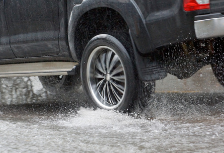Water Splashed by a car running through a flooded road after heavy rain, blurry movementの写真素材