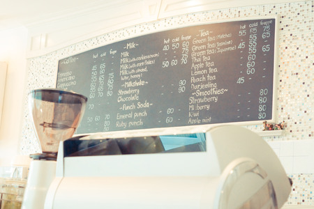 Coffee shop with coffee grinder and beverage menu boardの写真素材