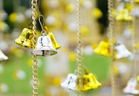 Golden and silver bells hung from chainsの写真素材