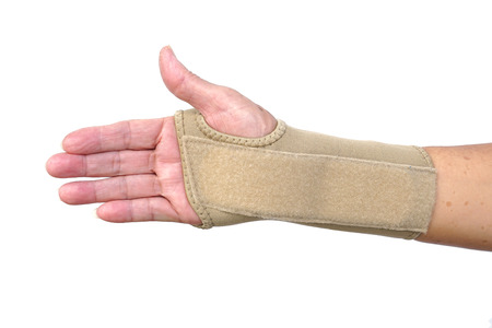 Old female hand wearing hand wrist therapy support glove isolated on whiteの写真素材
