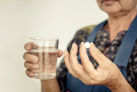 Hand of female elderly holding a white medicineの写真素材