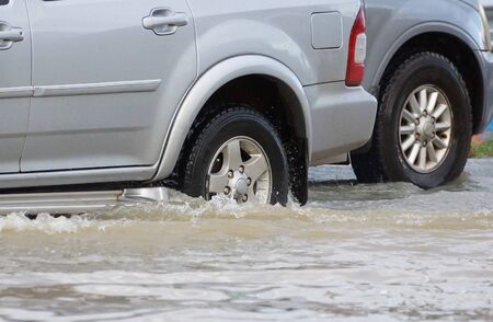 Water Splashed by a car running through a flooded road after heavy rain                             ...