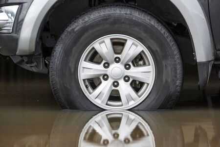 A wheel of a truck on a flooded road - Driving in wet condition conceptの写真素材