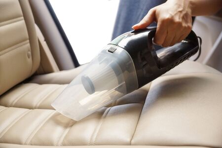 Cleaning a car using a vacuum cleanerの写真素材