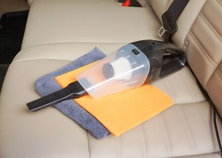 Cleaning a car using a vacuum cleaner and chamois clothの写真素材