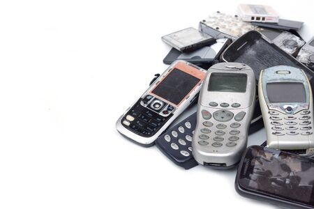 E-waste - Old mobile phones and battery isolated on white background                           の写真素材