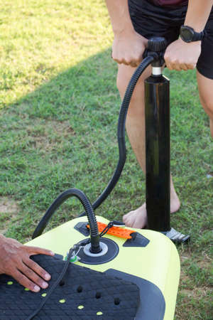 Man putting air into inflatable stand up paddle boardの写真素材