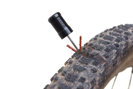 Mountain bike tire puncture repaired using a glue strip isolated on white backgroundの写真素材