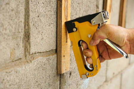 Heavy duty staple gun in use with wood workの写真素材