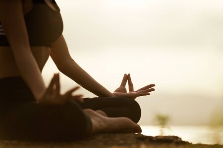 Silhouette young woman practicing yoga on the beach