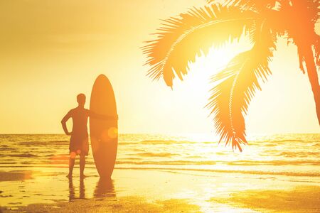 Happy surfer  standing with surfboards on the beachの写真素材