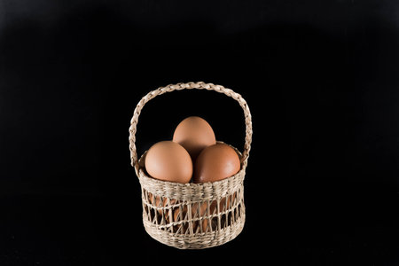 eggs in a basket on black backgroundの写真素材