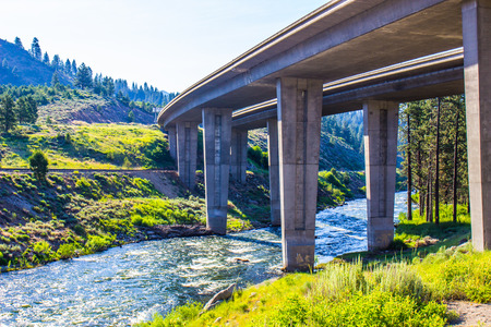 Large Highway Overpass Crossing River In Mountainsの写真素材