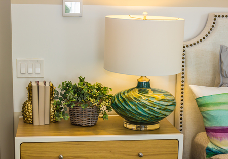 Modern Lamp & Decorations On Wooden Nightstand In Bedroomの写真素材