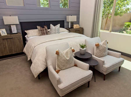 Master Bedroom With Two Arm Chairs At Foot Of Bedの写真素材