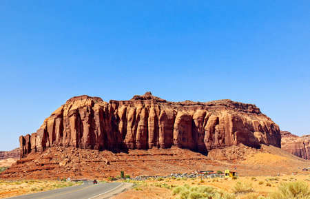 Large Mountain Overlooking Small Town In Monument Valley, U.S.の写真素材