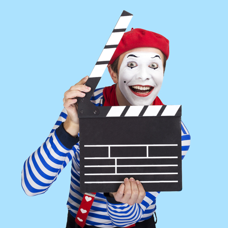 Emotional funny mime actor wearing sailor suit, red beret posing on blue backgroundの写真素材