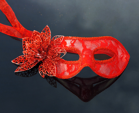 Red carnival masquerade mask on black tableの写真素材