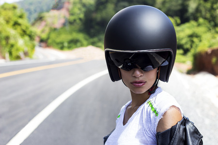 Beautiful woman in black helmet and leather jacket on scooter. Phuket, Thailandの写真素材
