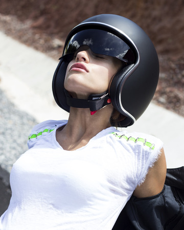 Beautiful woman in black helmet and leather jacket on scooter. Phuket, Thailandの写真素材