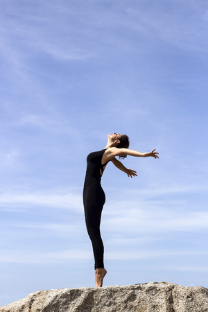 Yoga woman poses on beach near sea and rocks. Phuket, Thailandの写真素材