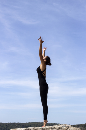 Yoga woman poses on beach near sea and rocks. Phuket, Thailandの写真素材