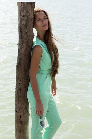 Woman on pier in stylish elegant clothes poses enjoying amazing view. Fashion look. Phuket, Thailandの写真素材