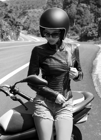 Beautiful woman in black helmet and leather jacket on scooter. Road of Phuket, Thailandの写真素材