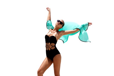 Dancing woman in black swimsuit sunglasses and turquoise beach dress poses on white isolated background. High fashion look.  Hair upの写真素材