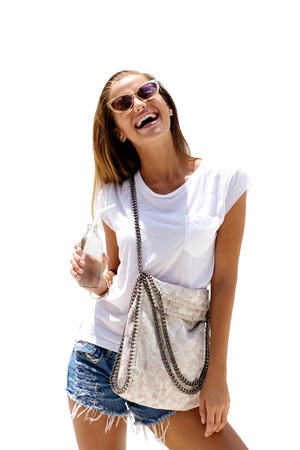 Fashion laughing woman wearing stylish clothes drinks soda and poses on isolated background.の写真素材