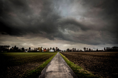 Old field path with houses extreme vanishing point perspective and dramatic sky.の写真素材