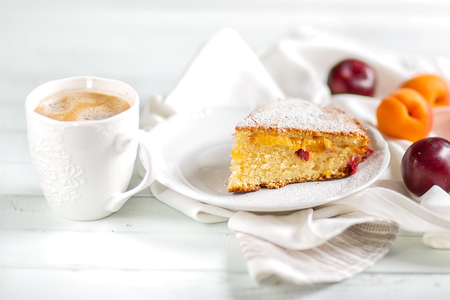 Homemade cake.Food preparation.fruit sweet cake with apricots and plums. Served table With coffee and cake. Kitchen itemsの写真素材
