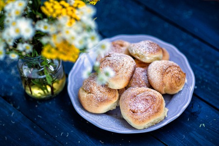 Homemade cake. Summer bouquet of wild flowers on a dark wooden table and bunsの写真素材