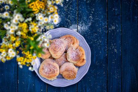 Homemade cake. Summer bouquet of wild flowers on a dark wooden table and bunsの写真素材